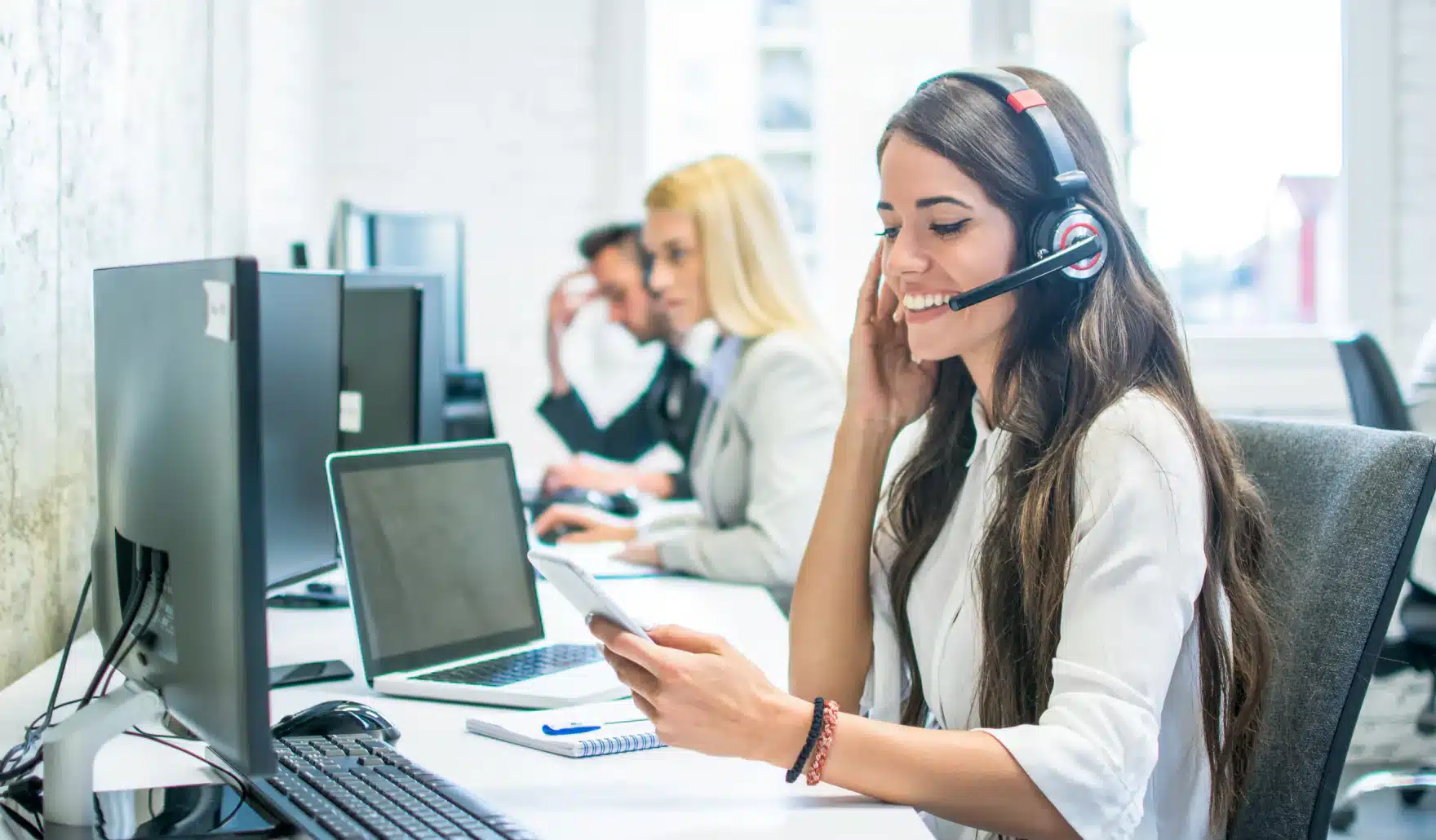 Answering service receptionist answering a call using a headset.